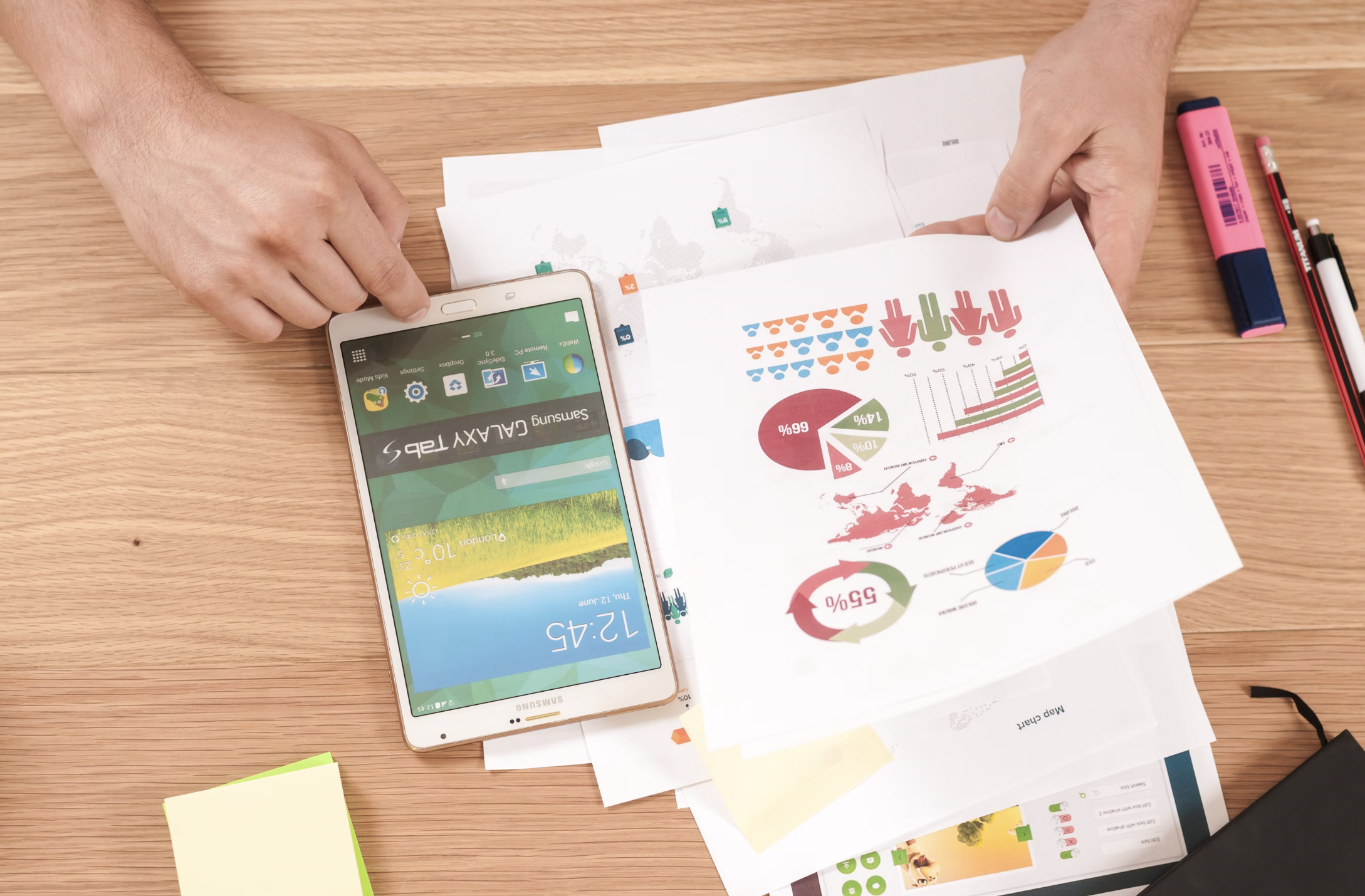a desk showing a phone with paper decorated by marketing graphs and charts showing shared goals